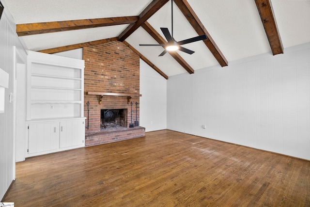 unfurnished living room with a brick fireplace, lofted ceiling with beams, a ceiling fan, and hardwood / wood-style flooring