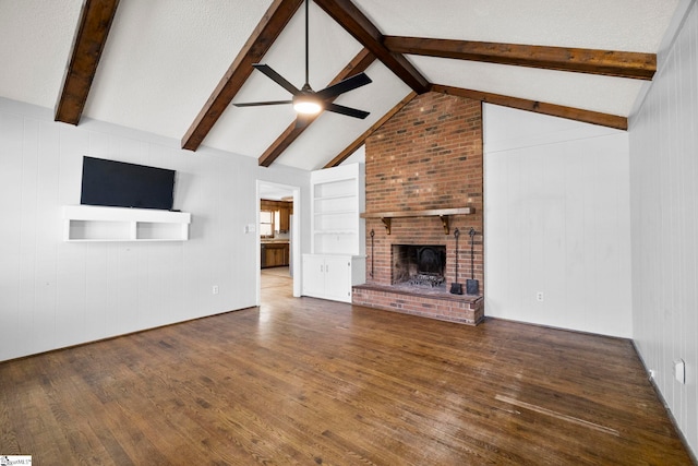 unfurnished living room featuring a fireplace, lofted ceiling with beams, a ceiling fan, and hardwood / wood-style flooring