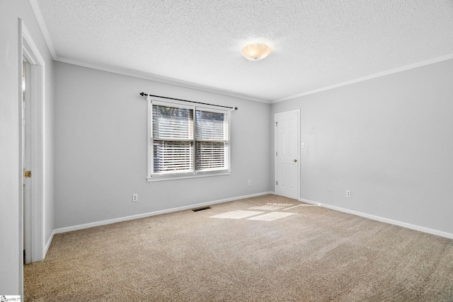 spare room featuring baseboards, visible vents, a textured ceiling, crown molding, and carpet flooring