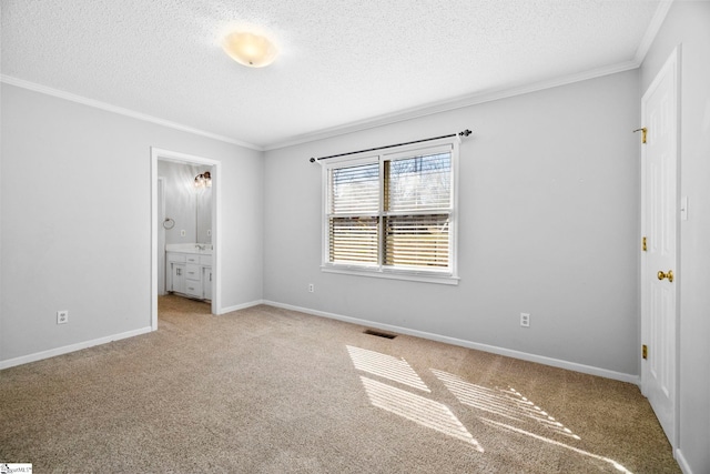 unfurnished bedroom featuring visible vents, a textured ceiling, crown molding, baseboards, and light colored carpet