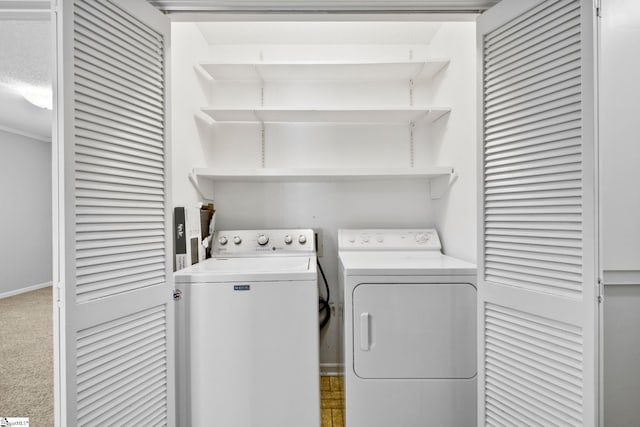 laundry room featuring baseboards, carpet floors, laundry area, and washer and clothes dryer