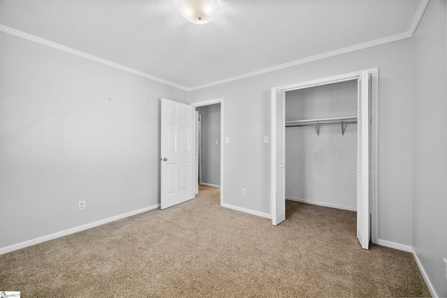 unfurnished bedroom with baseboards, carpet floors, ornamental molding, a closet, and a textured ceiling