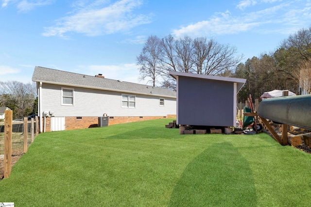 view of yard with an outdoor structure, cooling unit, fence, and a storage unit