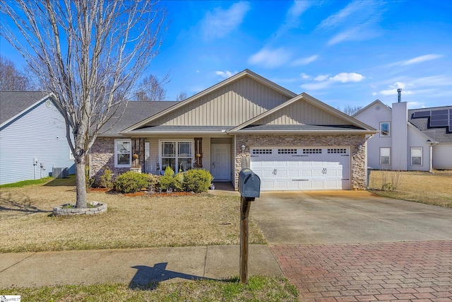 single story home featuring stone siding, an attached garage, decorative driveway, and a front yard