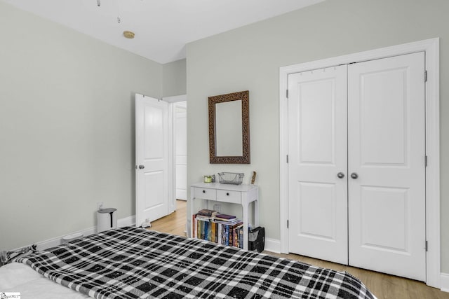 bedroom featuring a closet, baseboards, and light wood-style floors