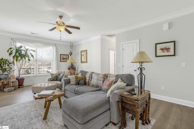 living room with a ceiling fan, crown molding, wood finished floors, and visible vents