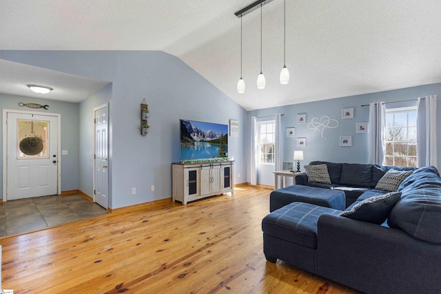 living room with lofted ceiling, hardwood / wood-style flooring, and baseboards