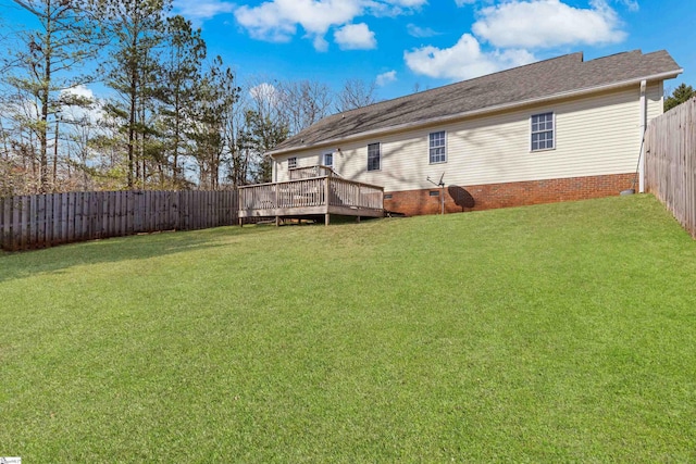 rear view of property with crawl space, a deck, a lawn, and a fenced backyard