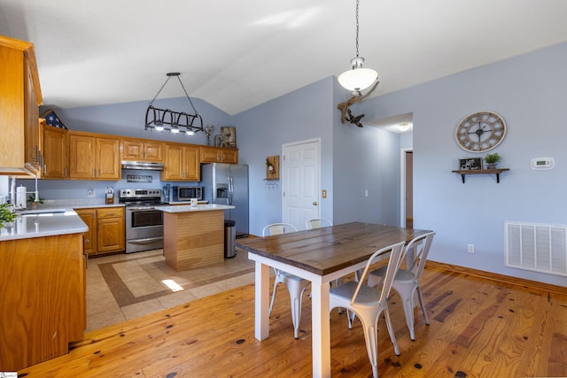 kitchen with visible vents, under cabinet range hood, light countertops, appliances with stainless steel finishes, and light wood-style floors