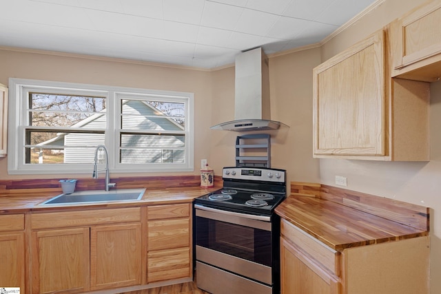 kitchen featuring light brown cabinets, butcher block counters, stainless steel range with electric stovetop, wall chimney exhaust hood, and a sink