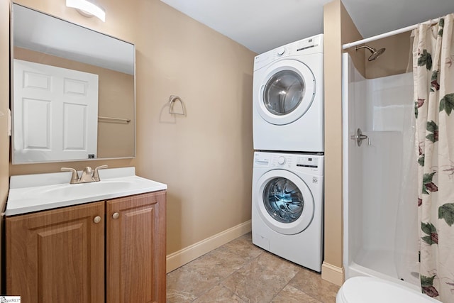 laundry area with a sink, baseboards, laundry area, and stacked washer / dryer