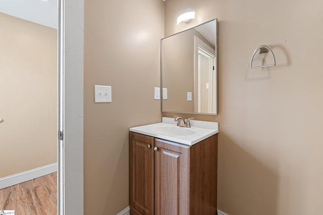 bathroom with baseboards, wood finished floors, and vanity