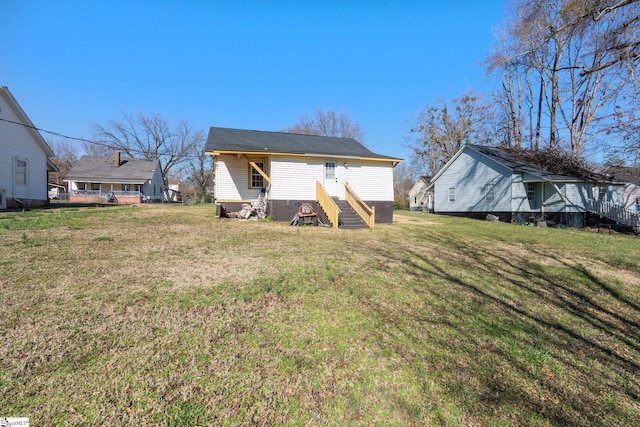 rear view of house featuring a lawn