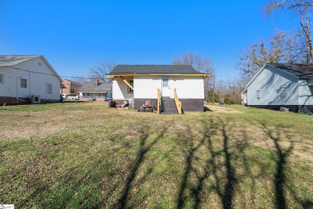 rear view of property with a lawn and entry steps