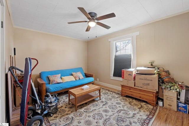 interior space with ornamental molding, baseboards, ceiling fan, and wood finished floors