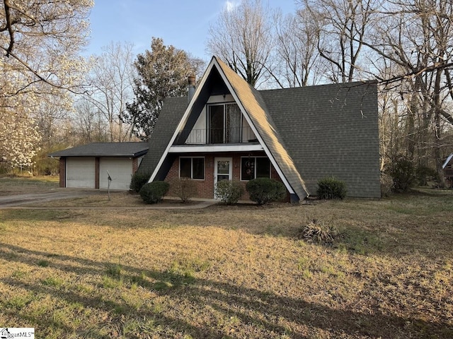 a-frame home featuring a front yard, a chimney, concrete driveway, a garage, and brick siding