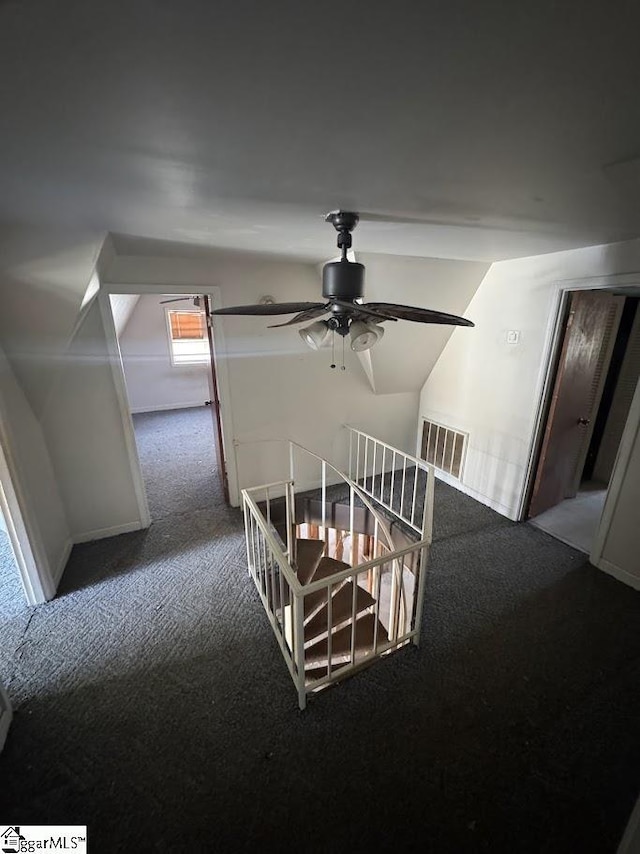 stairway with visible vents, carpet, and ceiling fan