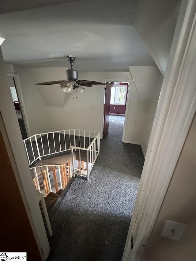 hallway with an upstairs landing and carpet flooring