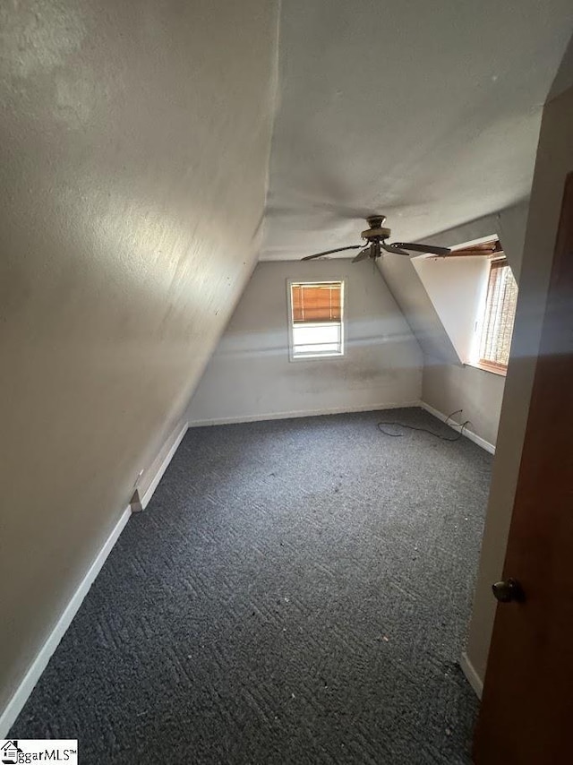 bonus room with a ceiling fan, a textured ceiling, carpet floors, baseboards, and vaulted ceiling