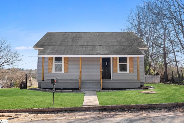 view of front of house featuring a porch, a front lawn, and a shingled roof