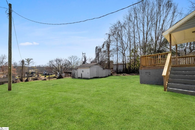 view of yard featuring a deck, an outbuilding, and stairs