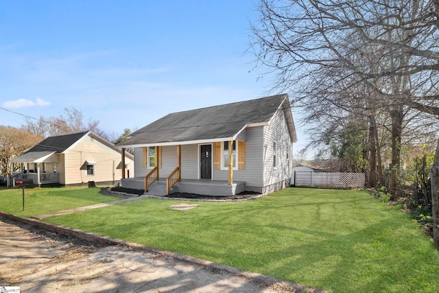 bungalow-style house with covered porch, a front lawn, and fence