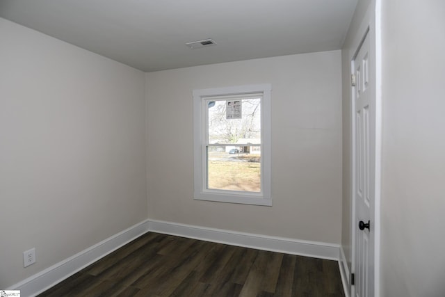 spare room with dark wood-type flooring, baseboards, and visible vents