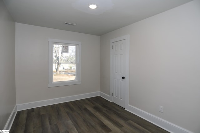 unfurnished room with dark wood finished floors, baseboards, and visible vents