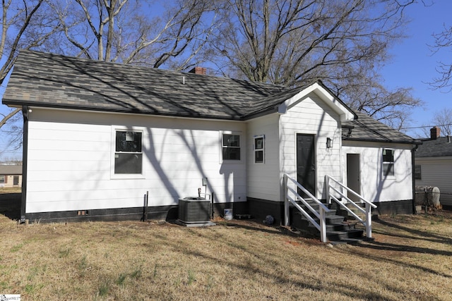 view of front of house featuring a chimney, central AC, a front lawn, and roof with shingles