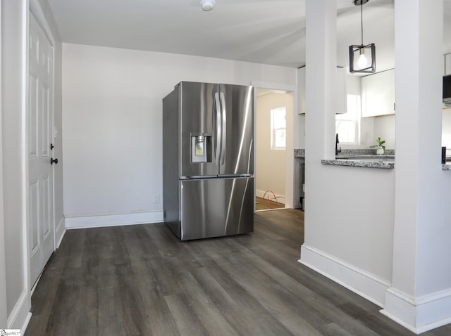 kitchen featuring baseboards, hanging light fixtures, stainless steel refrigerator with ice dispenser, dark wood-style floors, and white cabinets