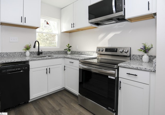 kitchen with light stone counters, dark wood finished floors, a sink, stainless steel appliances, and white cabinetry