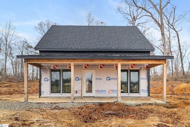 back of house featuring a shingled roof