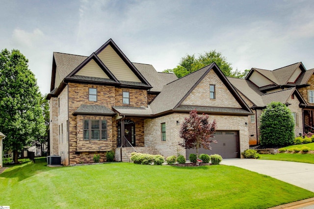 view of front of house featuring central air condition unit, concrete driveway, a front yard, a shingled roof, and a garage