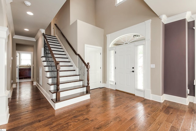 foyer entrance with ornamental molding, hardwood / wood-style flooring, recessed lighting, stairway, and baseboards