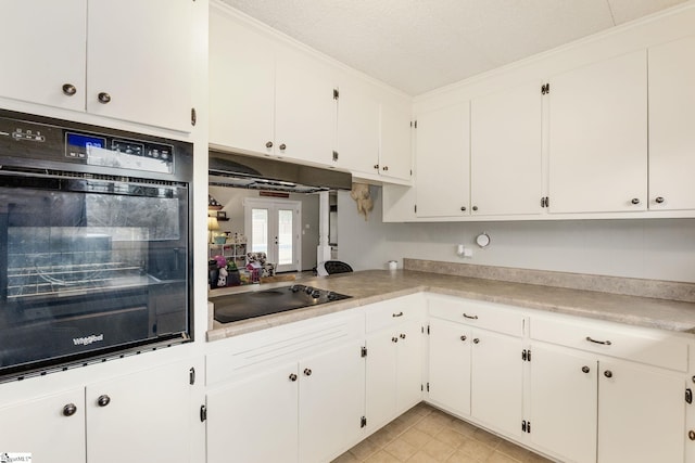 kitchen with black appliances, white cabinets, and under cabinet range hood