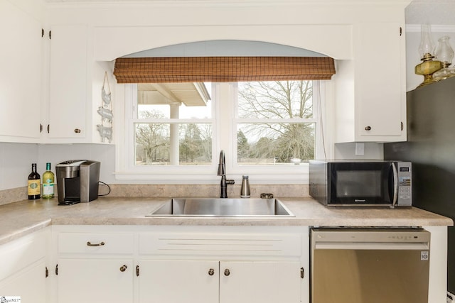 kitchen featuring a healthy amount of sunlight, dishwasher, white cabinets, and a sink