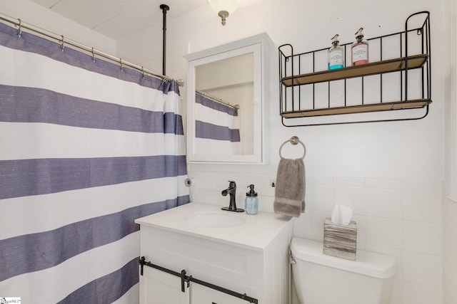 full bath with toilet, curtained shower, tile walls, and vanity