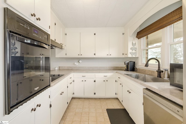 kitchen with white cabinetry, black appliances, light countertops, and a sink