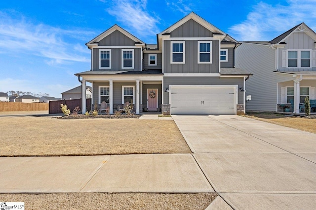 craftsman-style home featuring board and batten siding, fence, a porch, driveway, and an attached garage