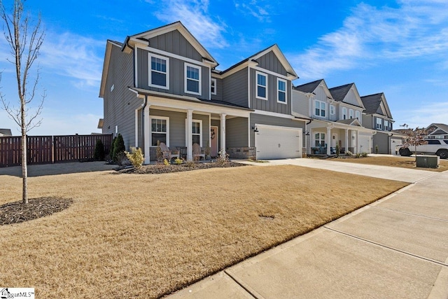 view of front of home with fence, a porch, concrete driveway, a garage, and board and batten siding