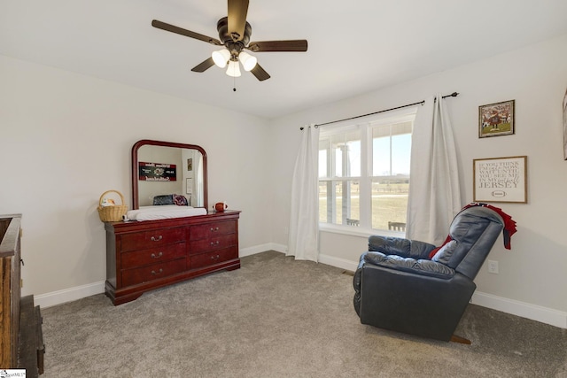 living area featuring baseboards, carpet, and a ceiling fan