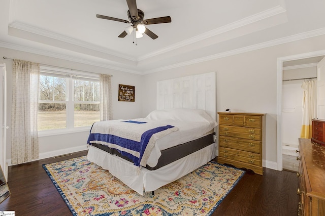 bedroom with a tray ceiling, baseboards, dark wood-style floors, and ornamental molding