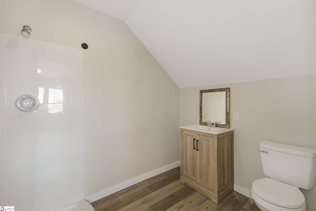 full bath featuring vanity, wood finished floors, baseboards, vaulted ceiling, and toilet