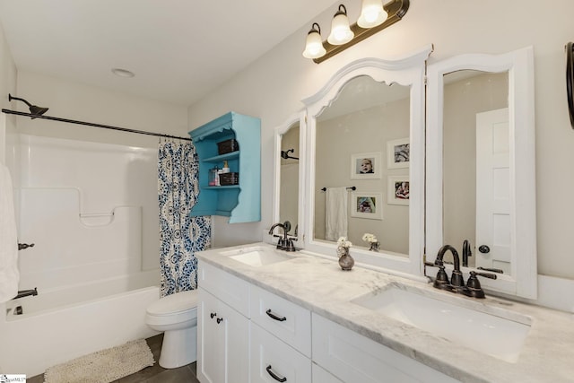 bathroom with double vanity, toilet, shower / tub combo, and a sink