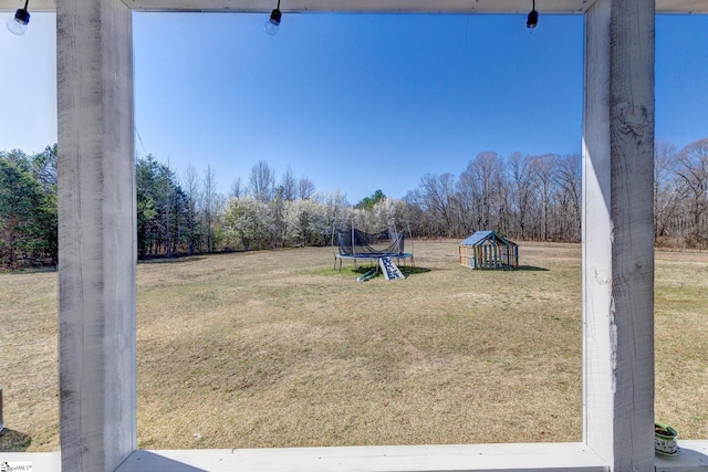 view of yard featuring a trampoline and a playground