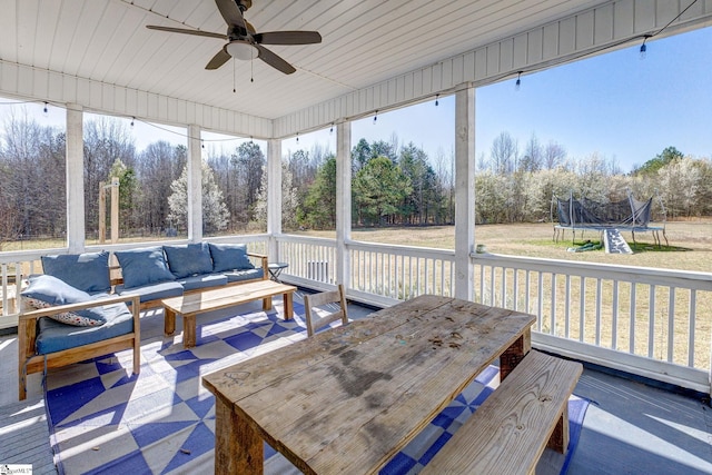 sunroom / solarium featuring a ceiling fan