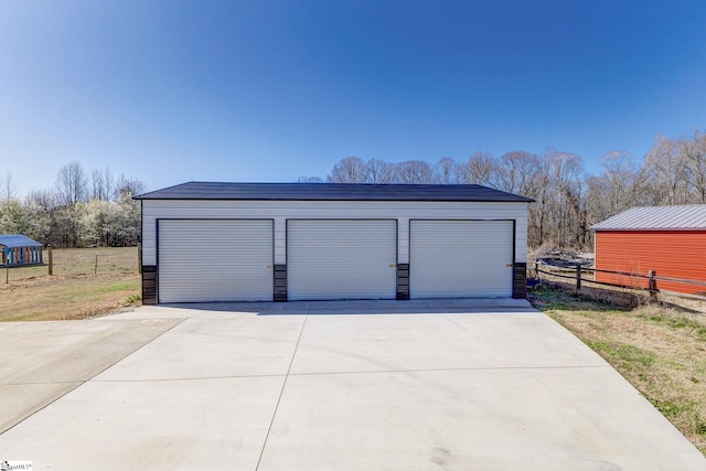 detached garage featuring fence