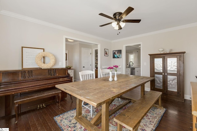 dining room with dark wood-type flooring, ornamental molding, and ceiling fan