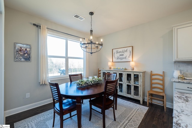 dining room with visible vents, baseboards, an inviting chandelier, and dark wood finished floors