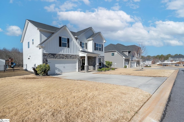 view of front of house featuring driveway, stone siding, a residential view, board and batten siding, and a garage